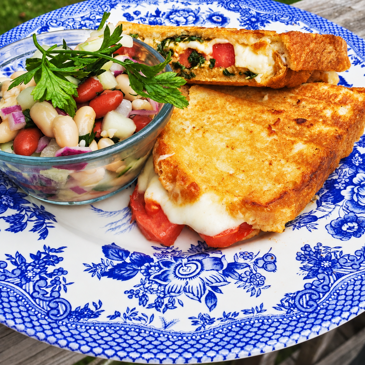 Toasted Caprese sandwich served with a cold cannellini-bean, tomato and cucumber salad