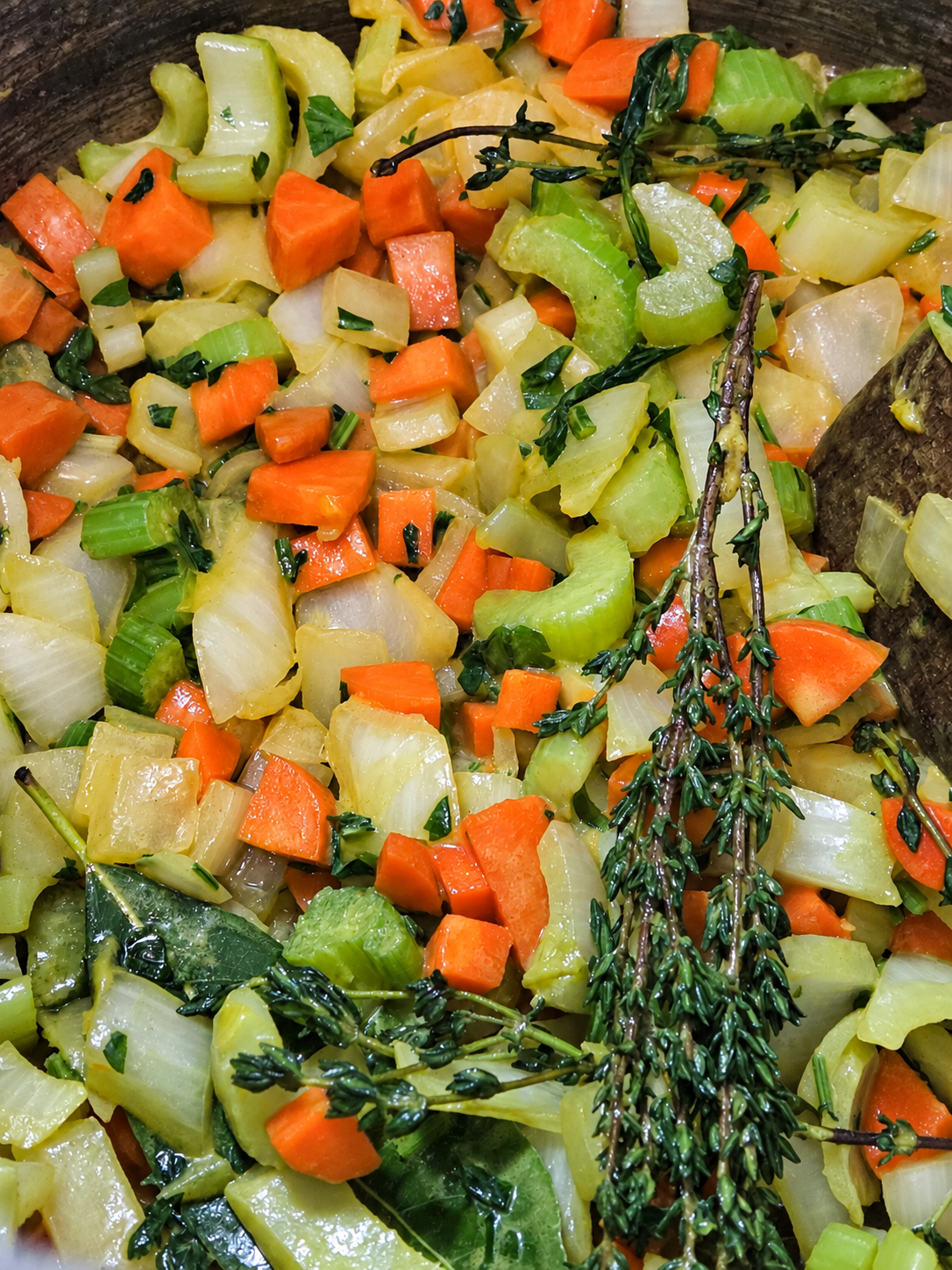 Softened soup vegetables with turmeric and fresh herbs