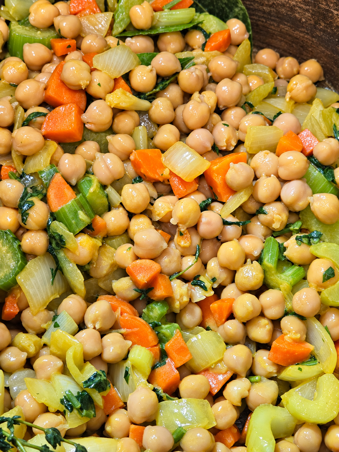 Chickpeas stirred into softened carrots, celery, onion, and herbs