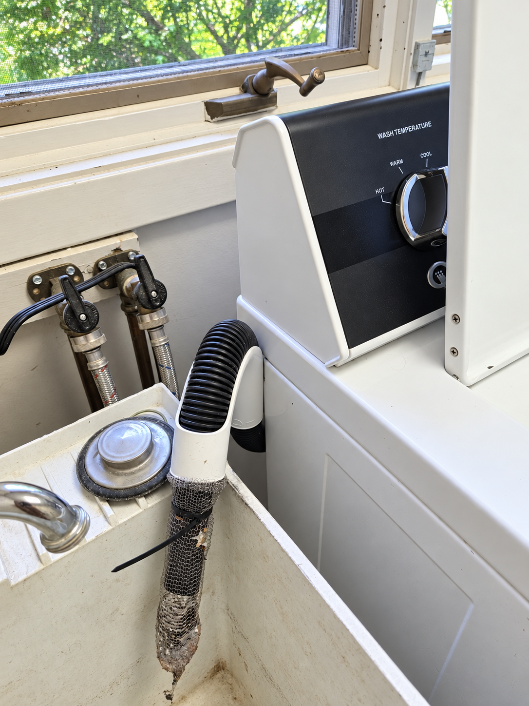 Speed Queen washer drain hose emptying into a laundry utility sink